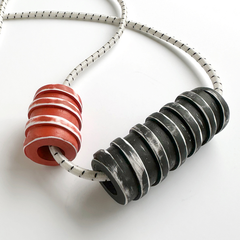Handmade polymer clay spiral beads on bungee cord.